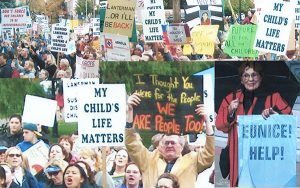 A collage of photos of activists holding signs at the Keep the Promise rally in 2003.