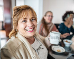 Mom holding coffee cup at a social meeting with other parents